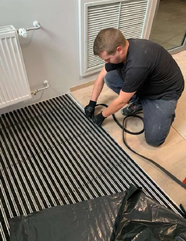 Installer rolling up the aluminium entrance mat at the hotel entrance