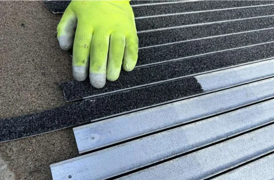 New replacement inserts being slid into the profiles of the existing entrance mat system