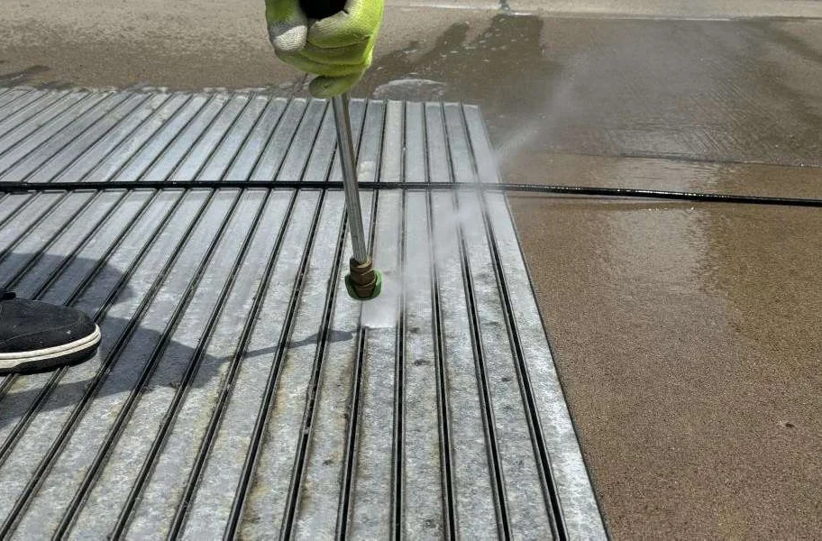 Profiles being cleaned with a pressure washer after removal of the old carpet inserts